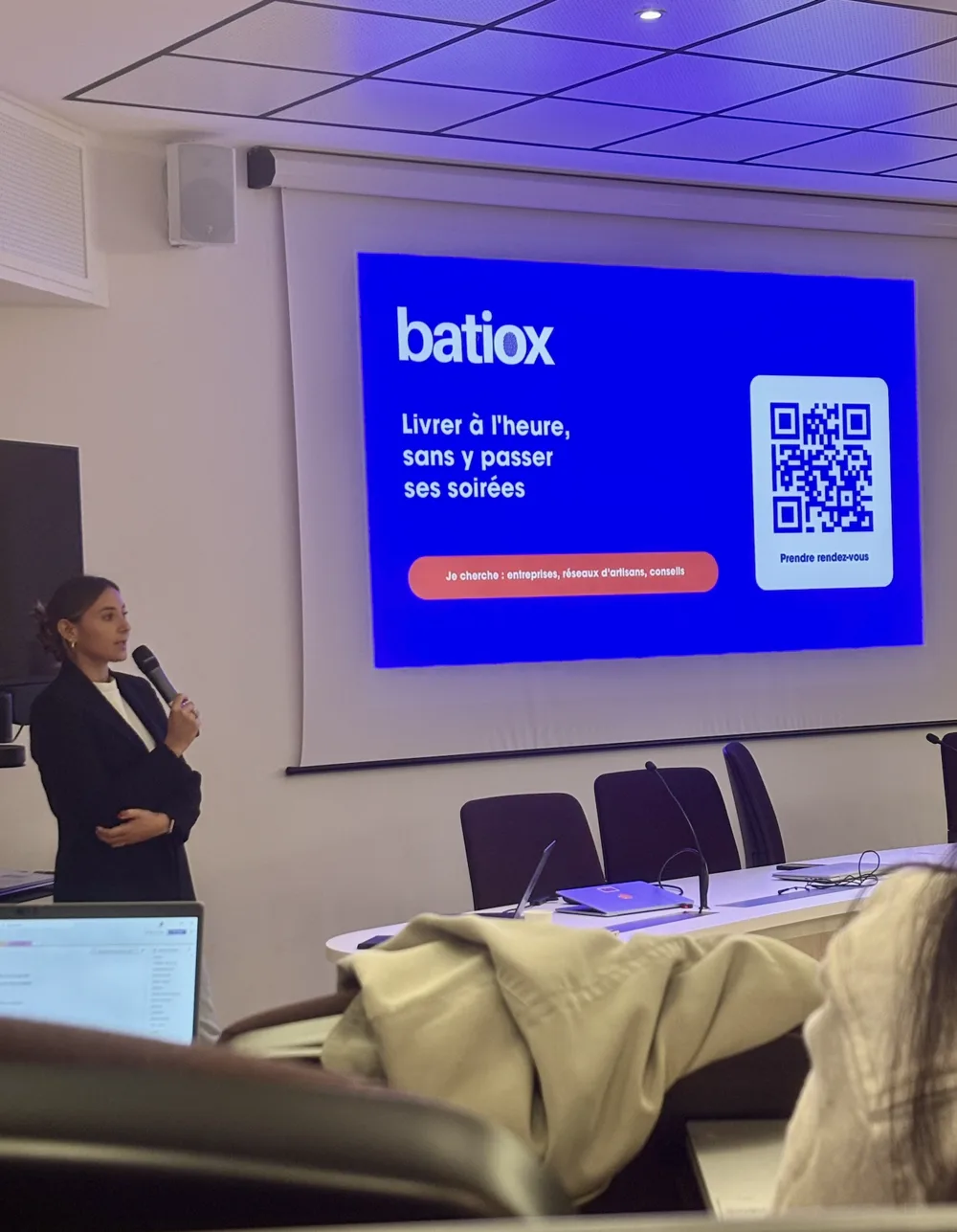 Alice Pasquier présente Batiox, le logo et le slogan du logiciel projetés derrière elle