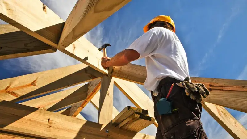Charpentier travaillant sur une toiture en bois