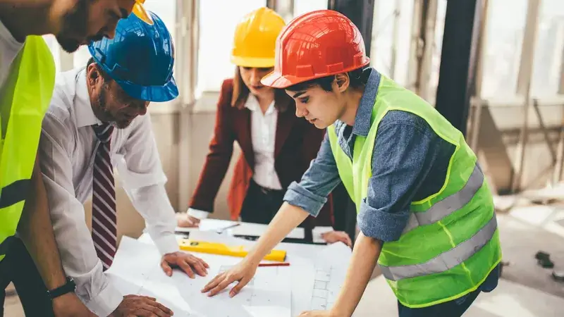 Réunion d'équipe BTP autour de plans de construction